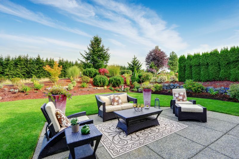 patio with stone floors outdoor sitting area and well trimmed landscaping all round