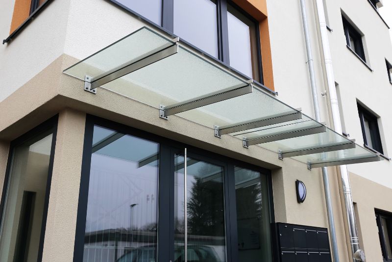 Fixed glass awning installed over a window on an Ipswich home